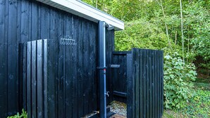 A wooden building with a metal door and a small wooden deck. - Cozy Holiday Home in Haderslev near Beach (Haderslev)