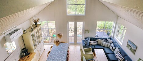Un interior estilo loft con comedor, asientos y amplios ventanales.