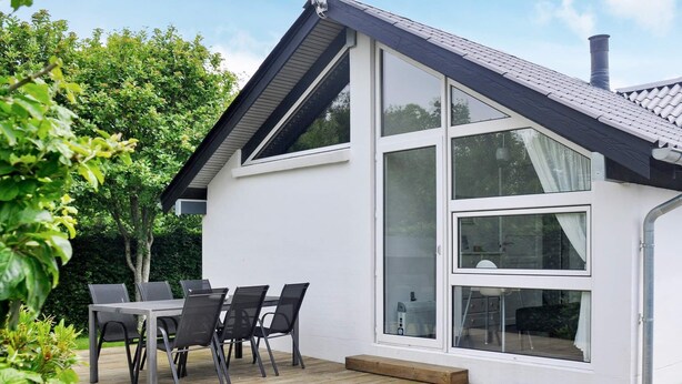 A modern house with a deck, large windows, and a chimney. - 4 Star Holiday Home in Struer (Struer)