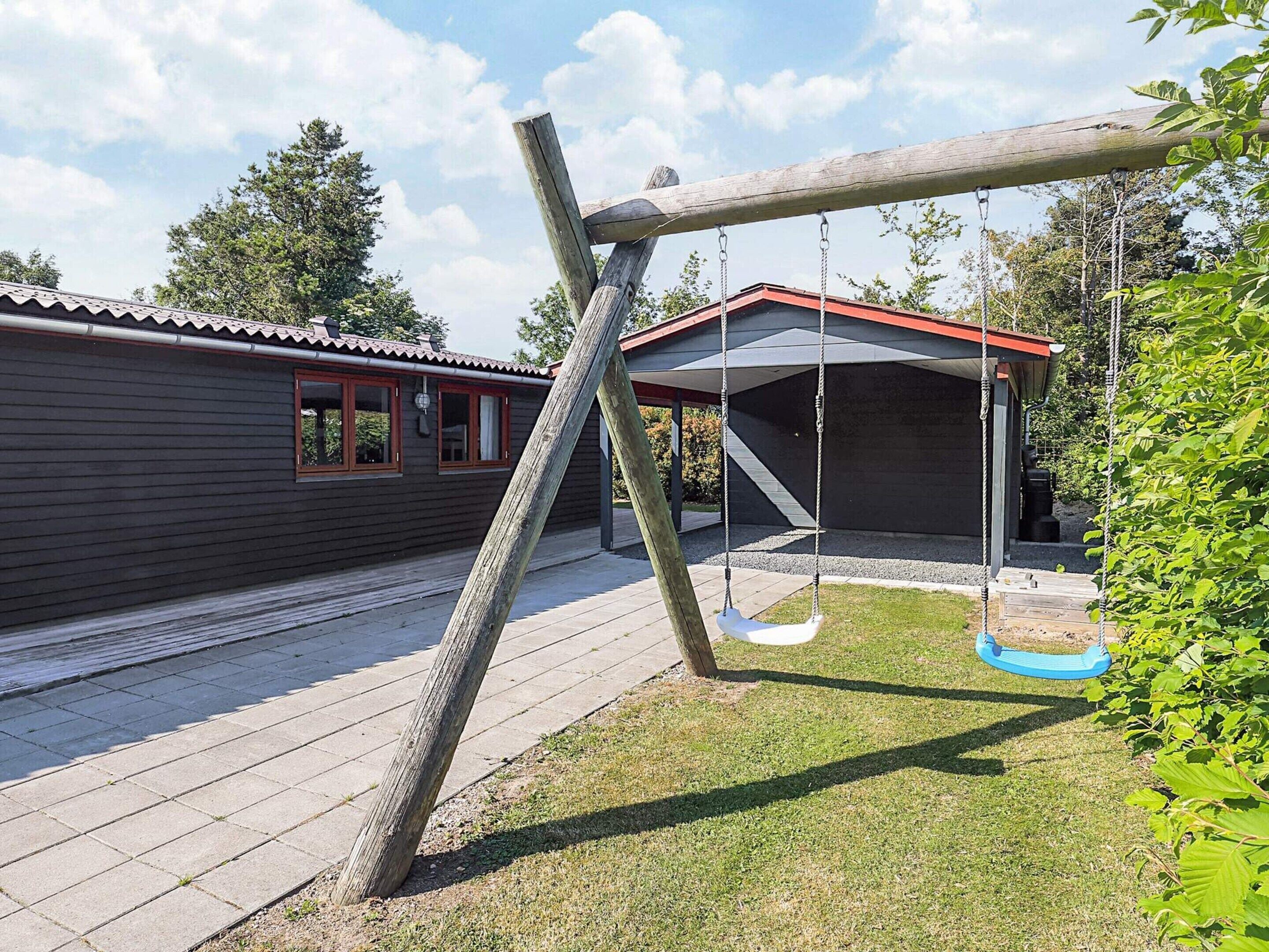 A wooden swing set in a backyard with a house in the background.