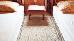 A small room with two beds, a bench, and a window. - 4 Person Holiday Home in Vistdal (Molde)