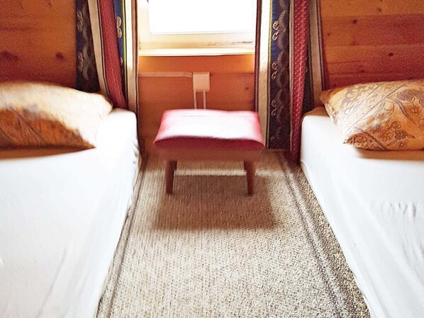 A small room with two beds, a bench, and a window. - 4 Person Holiday Home in Vistdal (Molde)