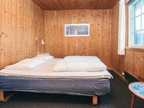 A wooden-paneled room with a bed, a small table, and a window. - Vintage Holiday Home in Harboøre with Hot Tub (Harboore)