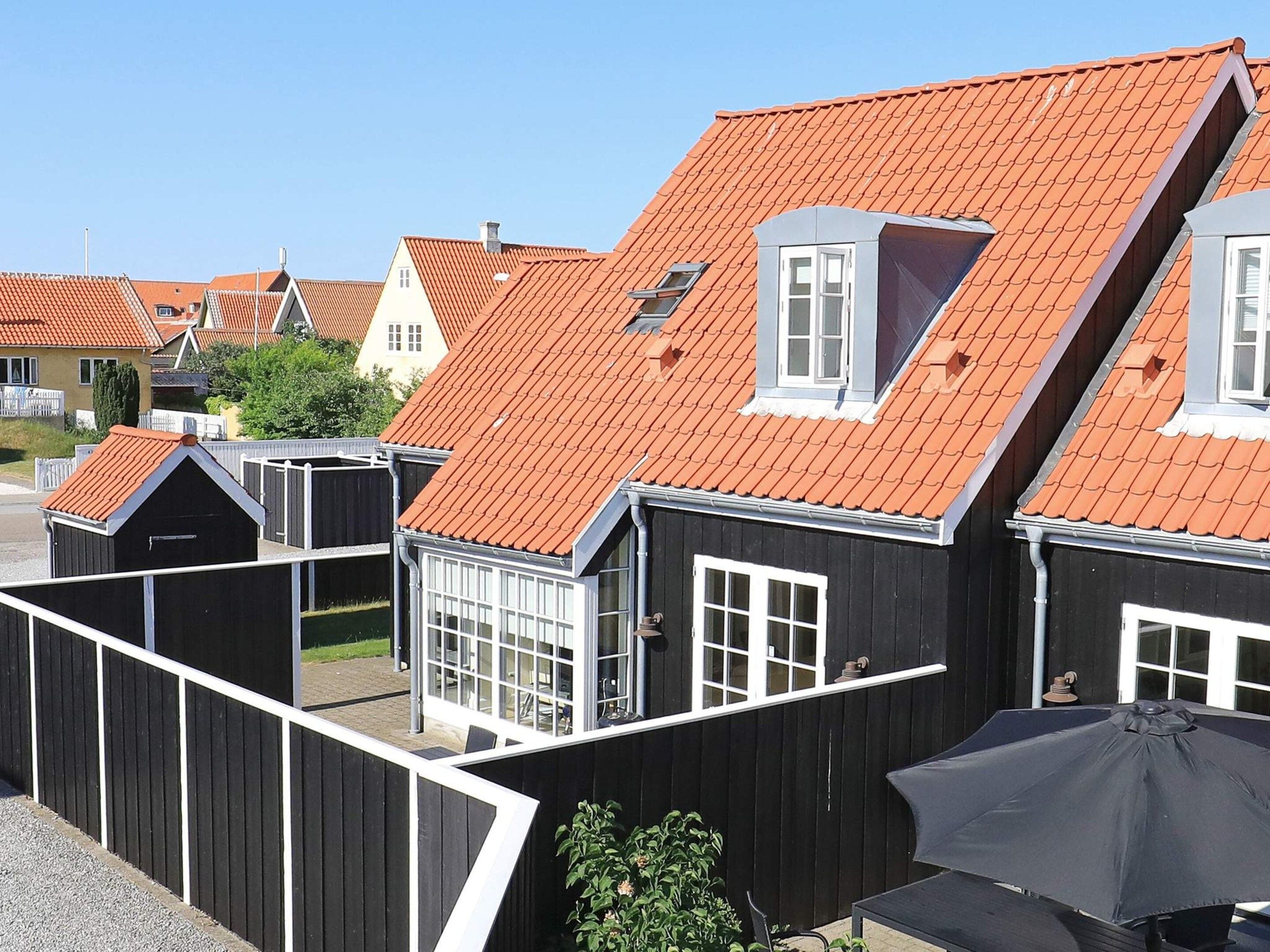 Huse i række med røde tagsten og hvide vinduesrammer.
