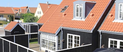 A row of houses with red-tiled roofs and white window frames.