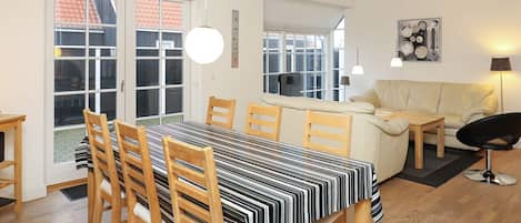 Un comedor con mantel a rayas, sillas de madera y un sofá.