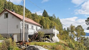 Ein Haus mit rotem Dach, einem Balkon und einem Steinfundament.