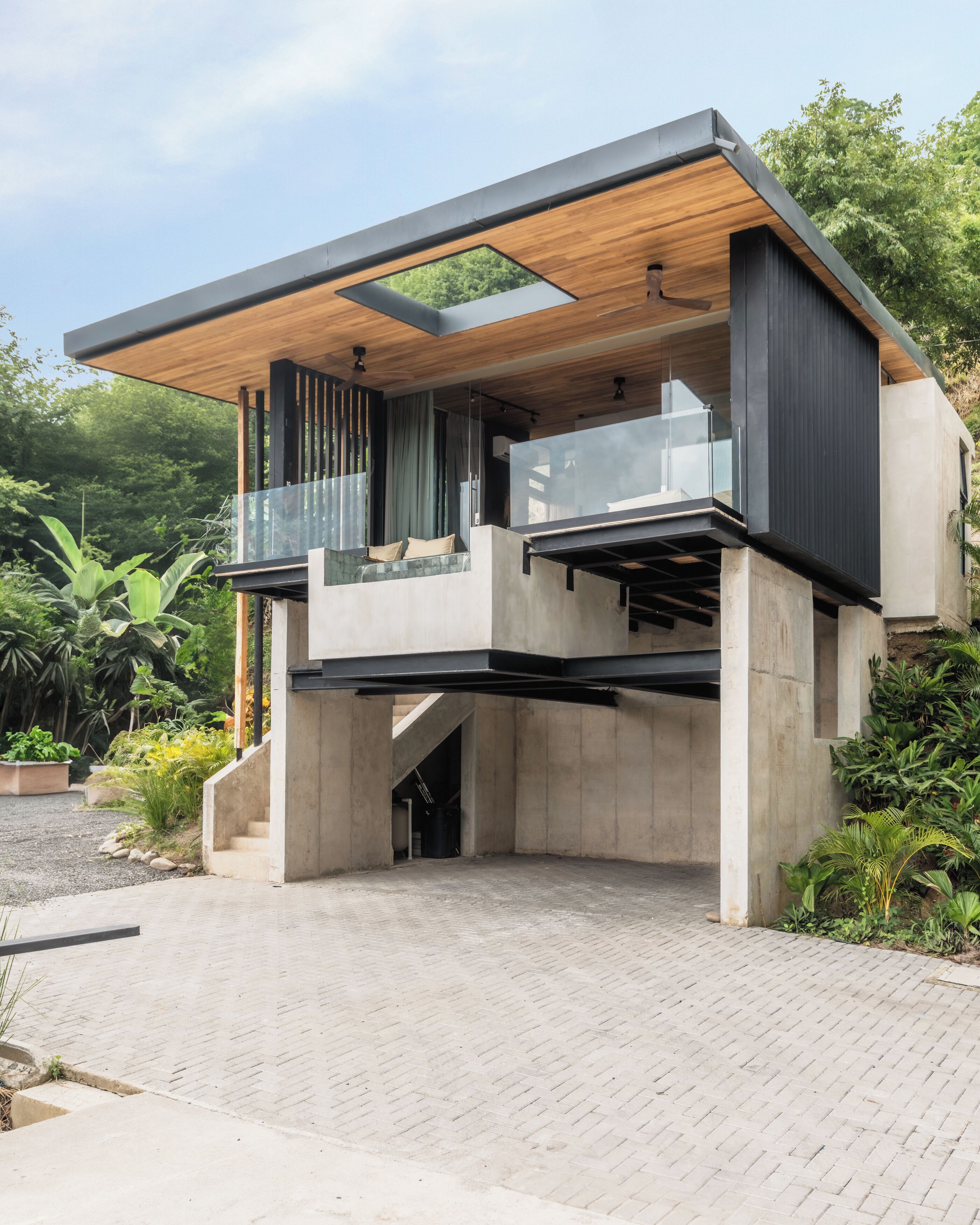 A modern house with a flat roof, large windows, and a balcony.