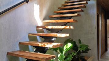 A modern staircase with wooden steps and a concrete wall.