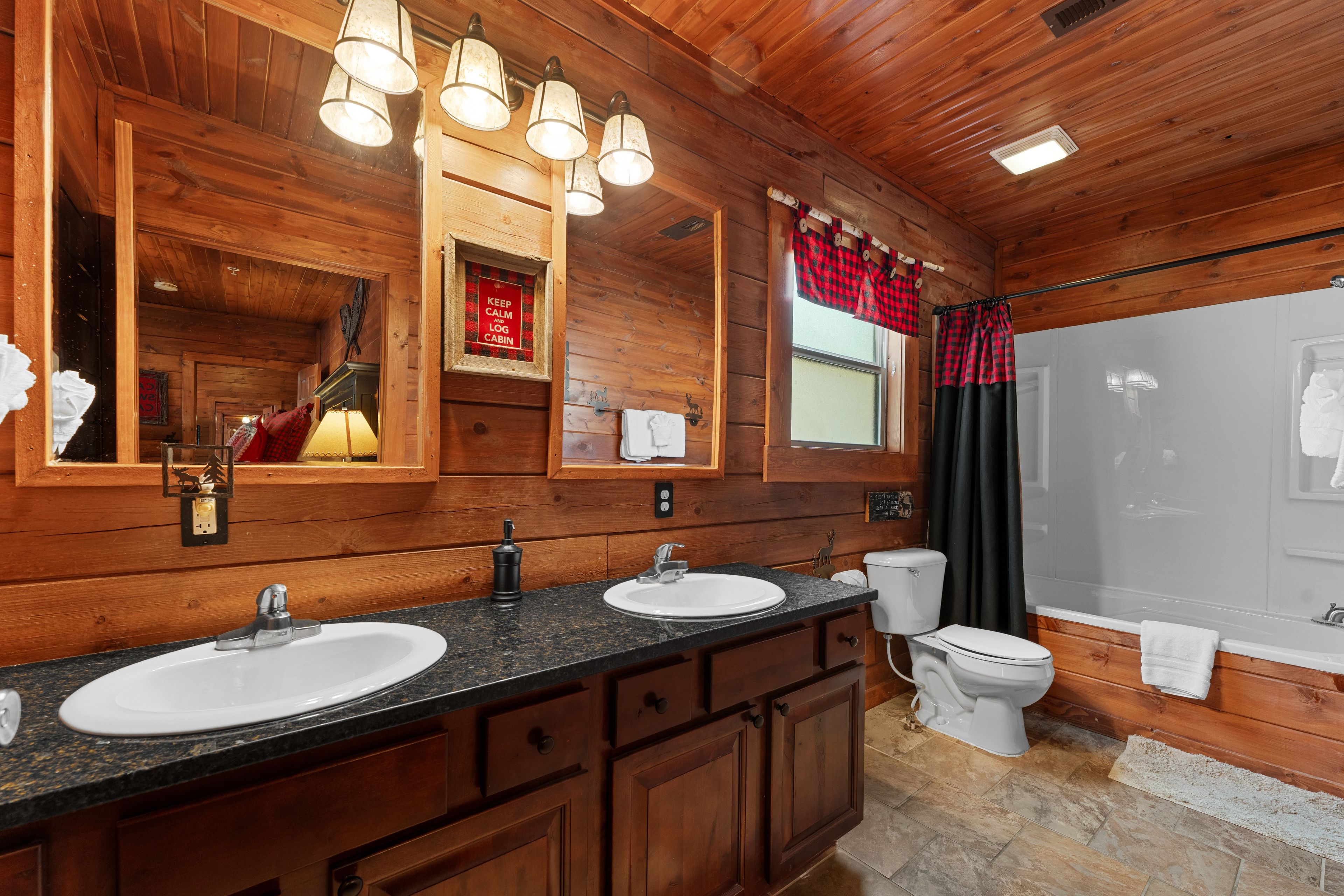 Un baño de cabaña de madera con dos lavamanos, un inodoro y una ducha.