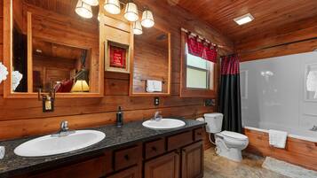 Un baño de cabaña de madera con dos lavamanos, un inodoro y una ducha.