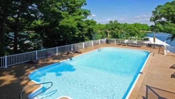 A rectangular swimming pool with a white deck and a metal railing. - Windjammer 33 (Osage Beach)