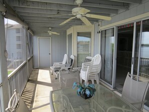 A covered outdoor area with white plastic chairs, a glass table, and ceiling fans. - Regatta BAY 404 (Lake Ozark)