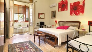 A bedroom with a bed, bedside tables, a TV, and a window with curtains. - Residenza Oltrarno, an elegant apartment in the historic center of Florence (Firenze)