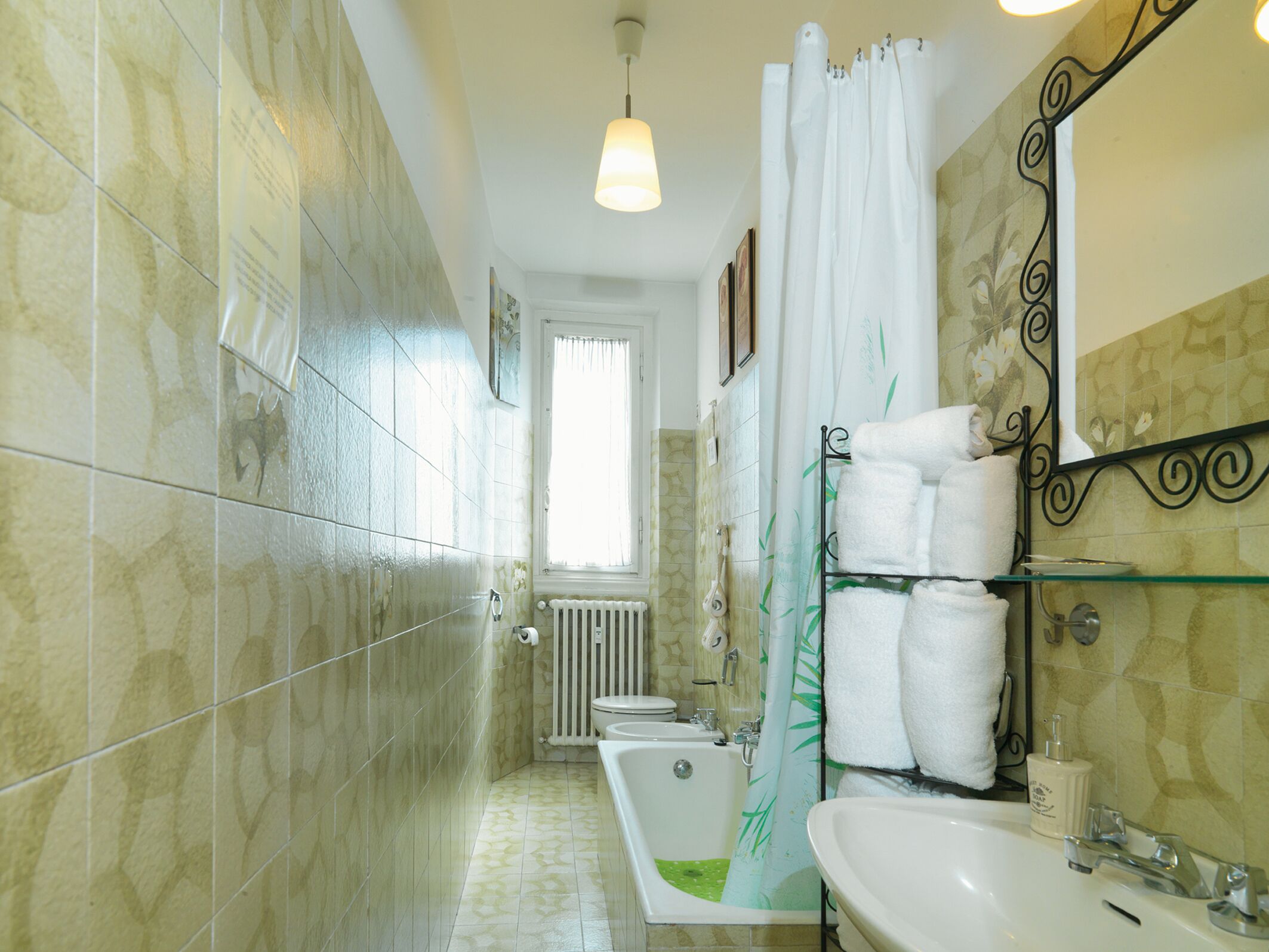 Un bagno con vasca, lavandino e tenda da doccia.