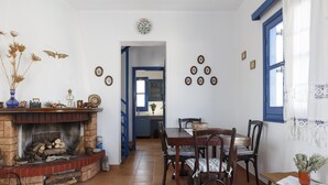 Un comedor con chimenea de ladrillo, mesa de madera y sillas.
