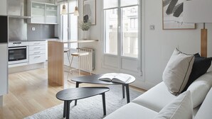 A modern living room with a sofa, a small table, and a kitchen area in the background. - Mirakruz Terrace by FeelFree Rentals (San Sebastin)