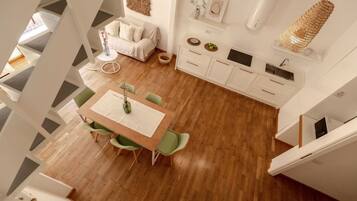 Un ambiente moderno con zona pranzo, cucina e soggiorno.