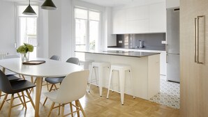 A modern kitchen with white cabinets, a stainless steel refrigerator, and a wooden floor. - Larroka by FeelFree Rentals (San Sebastián)