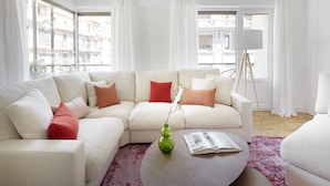 A modern living room with a white sectional sofa, a round coffee table, and a floor lamp. - Larroka by FeelFree Rentals (San Sebastián)