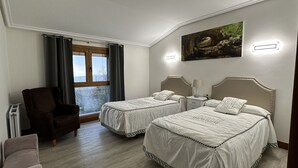 A hotel room with two beds, a chair, a radiator, a window with curtains, and a painting on the wall. - Rural house Caserío Ibarrola Txiki for 12 people. (Usurbil)