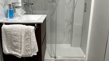 Een douche, een haardroger, handdoeken, toiletpapier