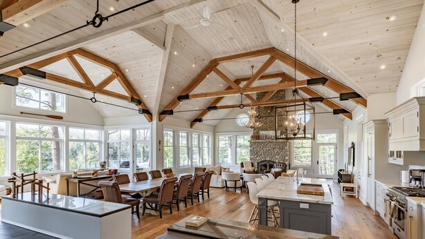 Una cocina amplia con techos altos, ventanas grandes y una chimenea de piedra.
