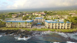 Un hotel costero con varias construcciones, un litoral rocoso y vista al océano.