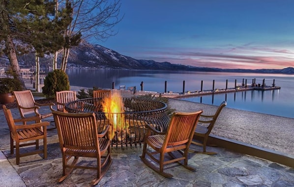 Relax by the lake with a warm fire pit surrounded by comfortable seating.