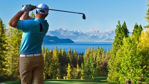 A person playing golf on a course with a view of mountains and a body of water. - Fully Stocked & Spacious McCloud 3Bed/ 2.5  Walk to Lake 1-Car Garage (Incline Village)