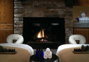 Relax by the fireplace in this inviting room, featuring a cozy seating area and amenities for a comfortable stay.
