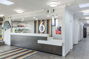 A reception desk with a large number '6' sign, a striped wall, and a modern design.