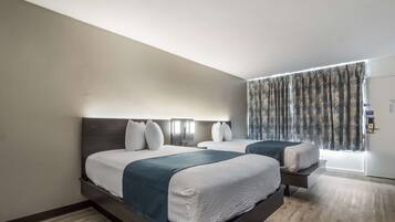 A modern hotel room with two beds, a large window with patterned curtains, and a wooden floor.