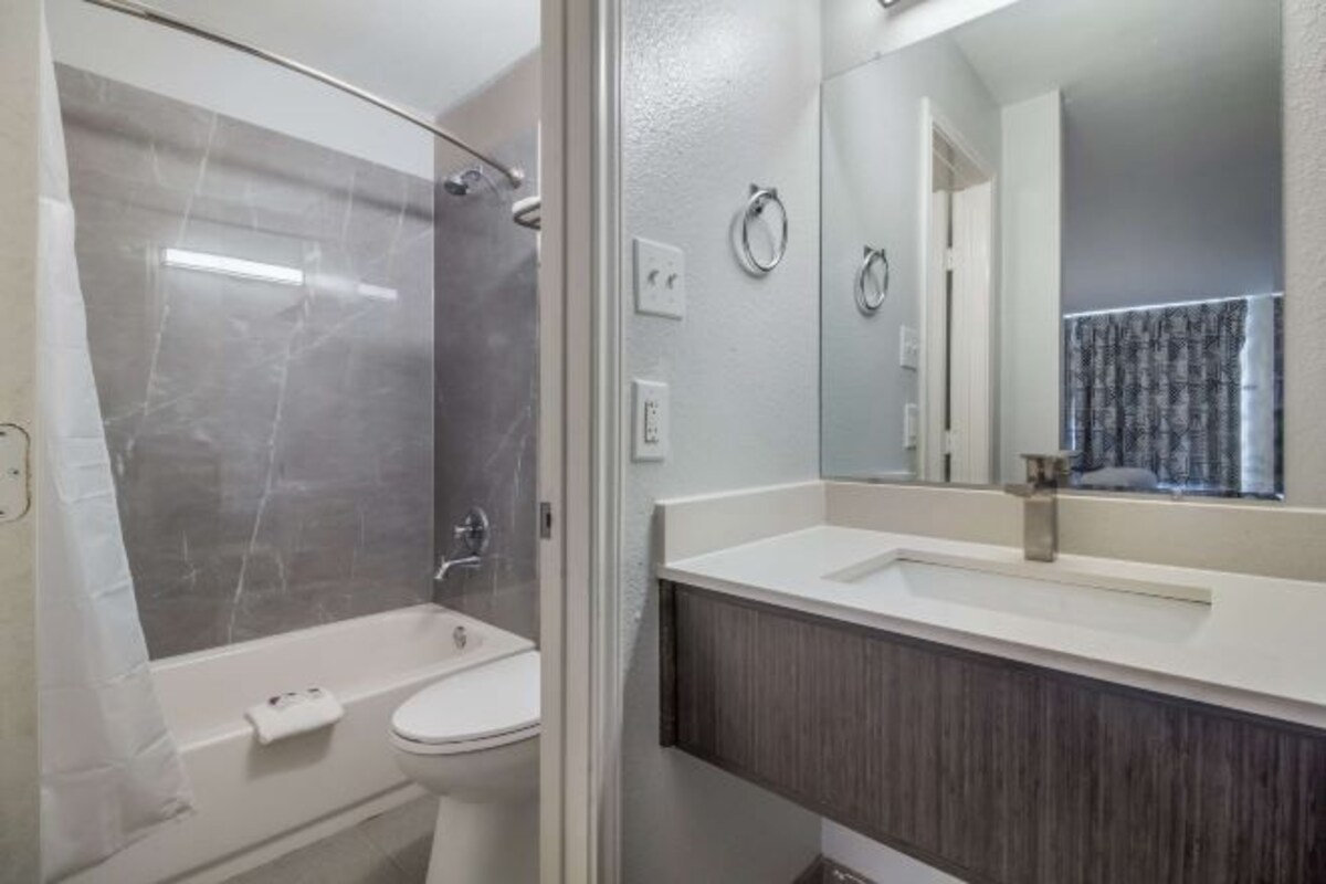 Un baño con ducha, inodoro y lavamanos.