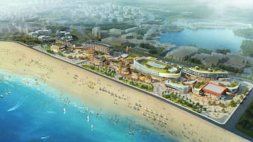 Un complejo turístico frente a la playa, con edificios modernos y un río.