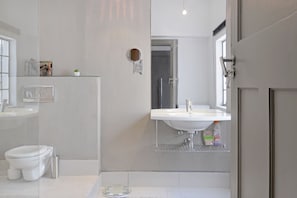 A modern bathroom with a toilet, sink, and shower area.