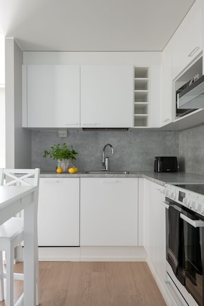 Apartamento, 3 quartos | Cozinha privada | Geladeira grande, micro-ondas, fogão, cooktop