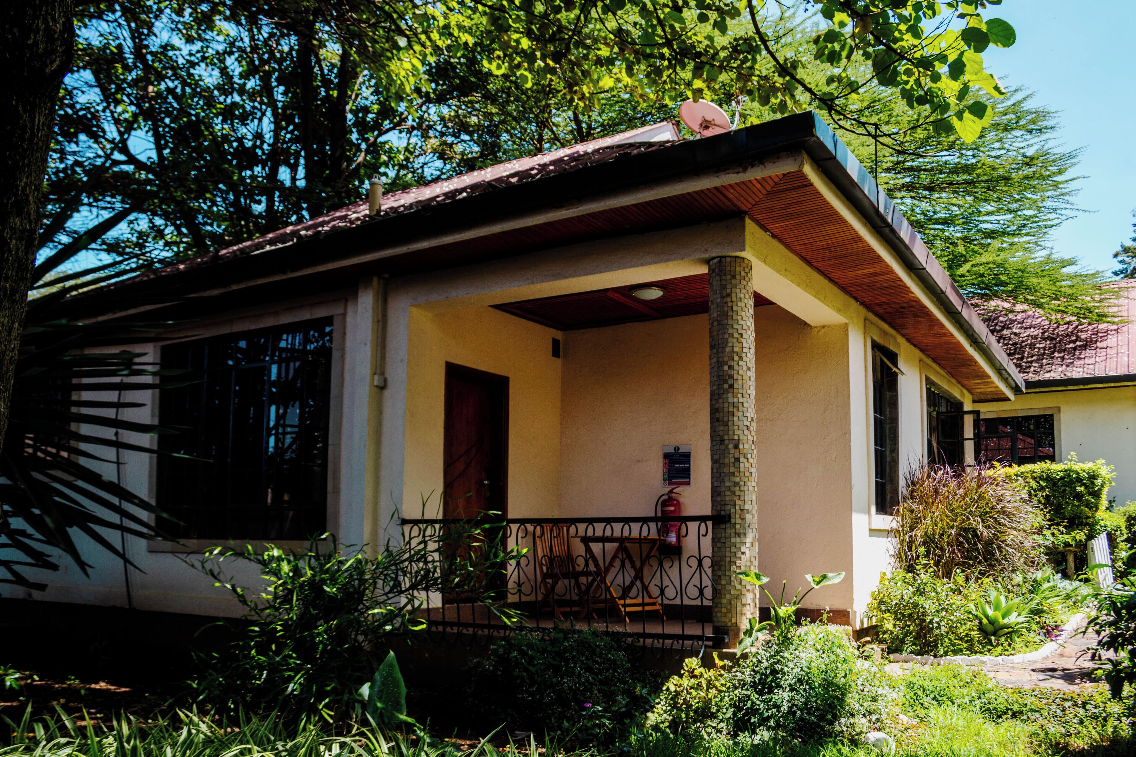 A house with a porch, a fire extinguisher, and a satellite dish.