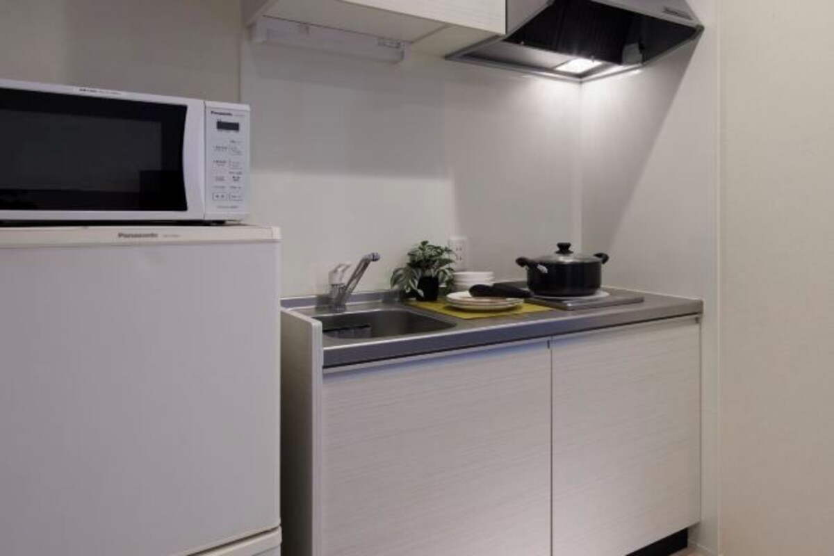 A kitchen with a microwave, sink, and cabinets.
