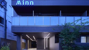 A modern building with a prominent 'Minn' sign at the top. - Minn Kamata (Tokyo)