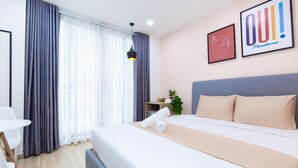 A modern hotel room with a neatly made bed, a small table, and a chair. - Cozrum Homes Charming Corner (Ho Chi Minh City)