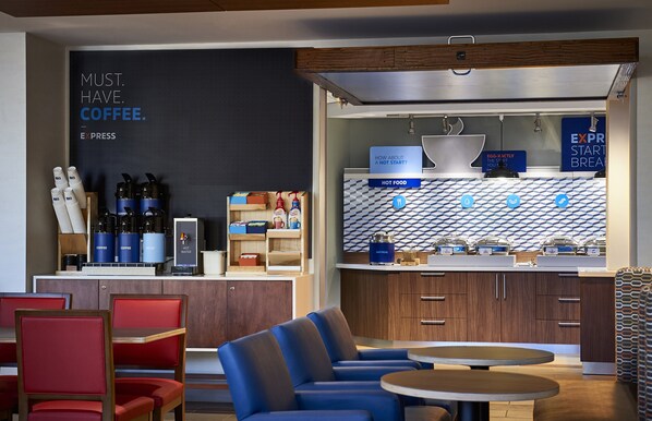 A modern coffee shop with seating, a coffee station, and a kitchen area. - Holiday Inn Express & Suites Madison West - Middleton by IHG (Middleton)