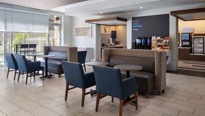 A modern cafe with seating arrangements, a coffee station, and a menu board. - Holiday Inn Express & Suites Madison West - Middleton by IHG (Middleton)