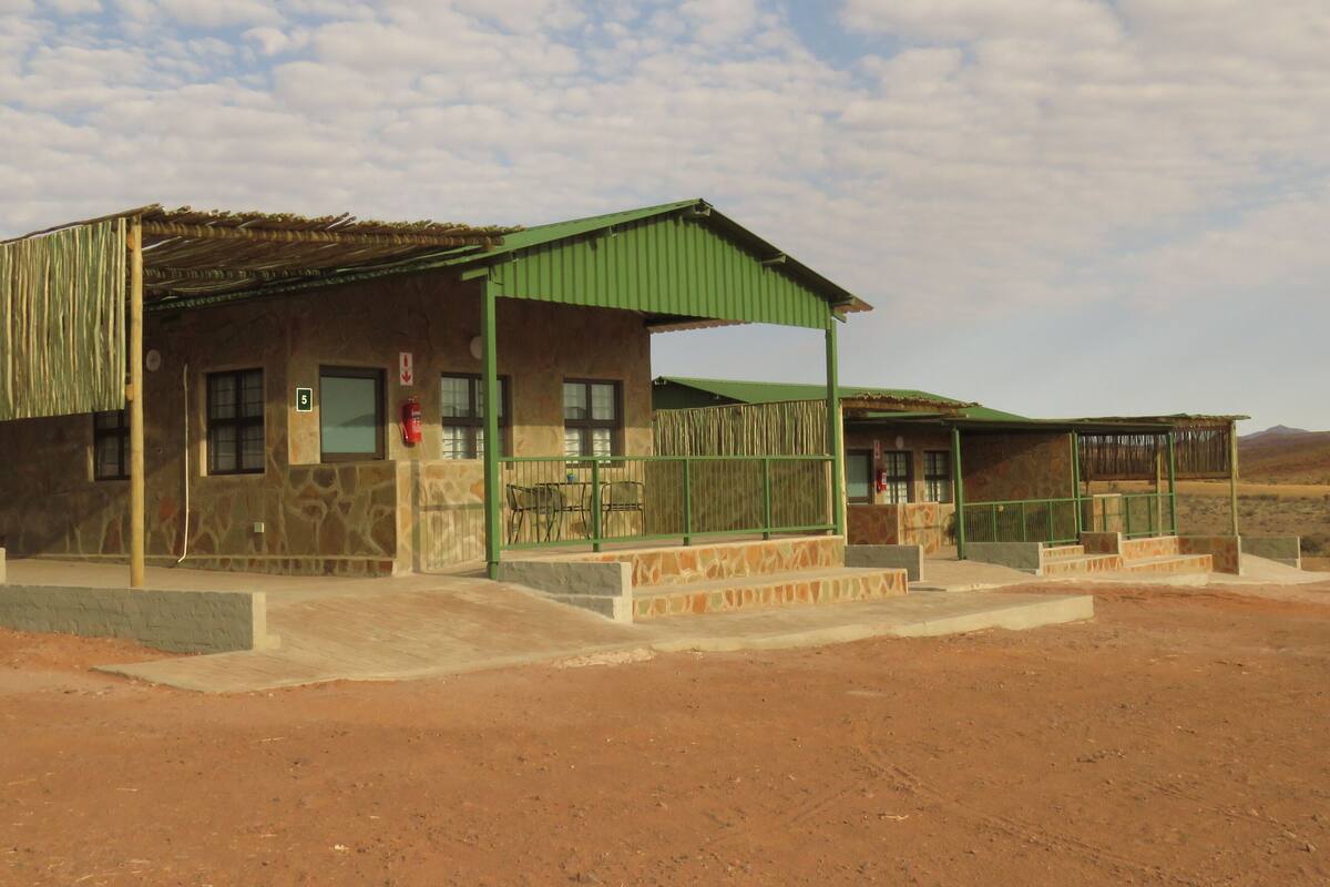 A building with a green roof and a fire extinguisher mounted on the wall.