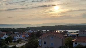 A residential area with houses, a road, and a body of water in the background.
