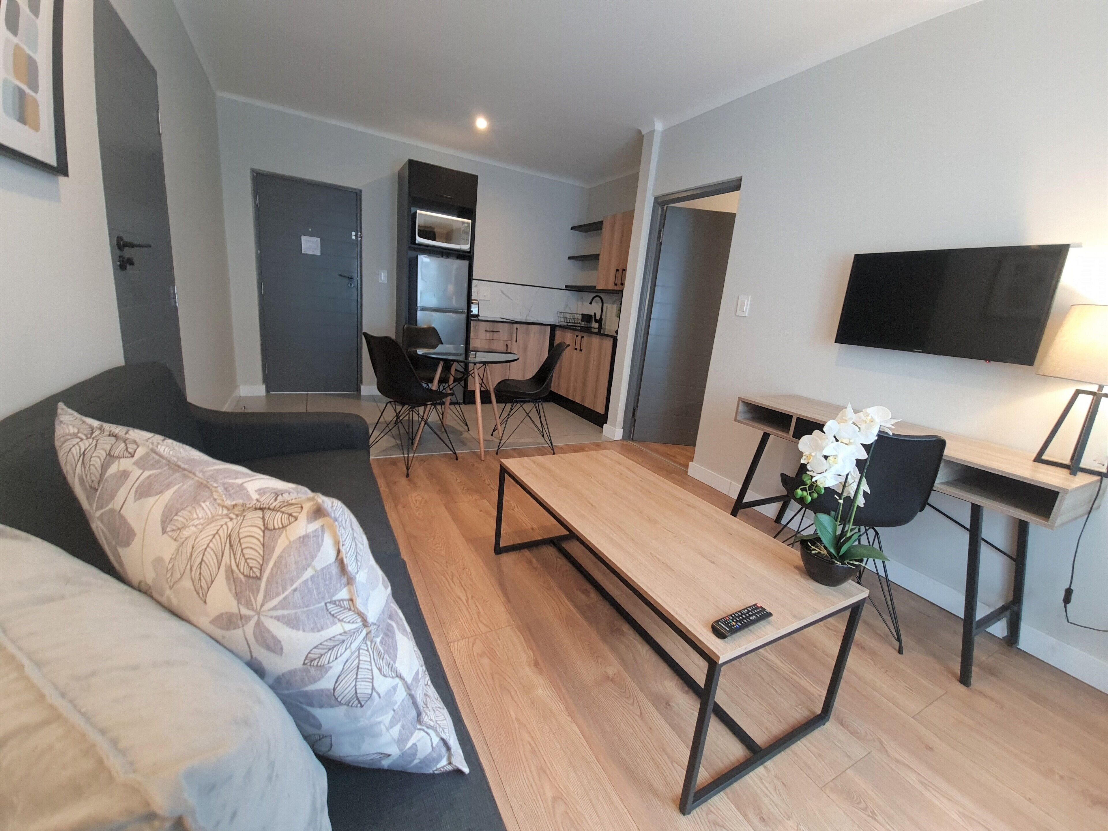 Een moderne woonkamer met een bank, een salontafel en een televisie.