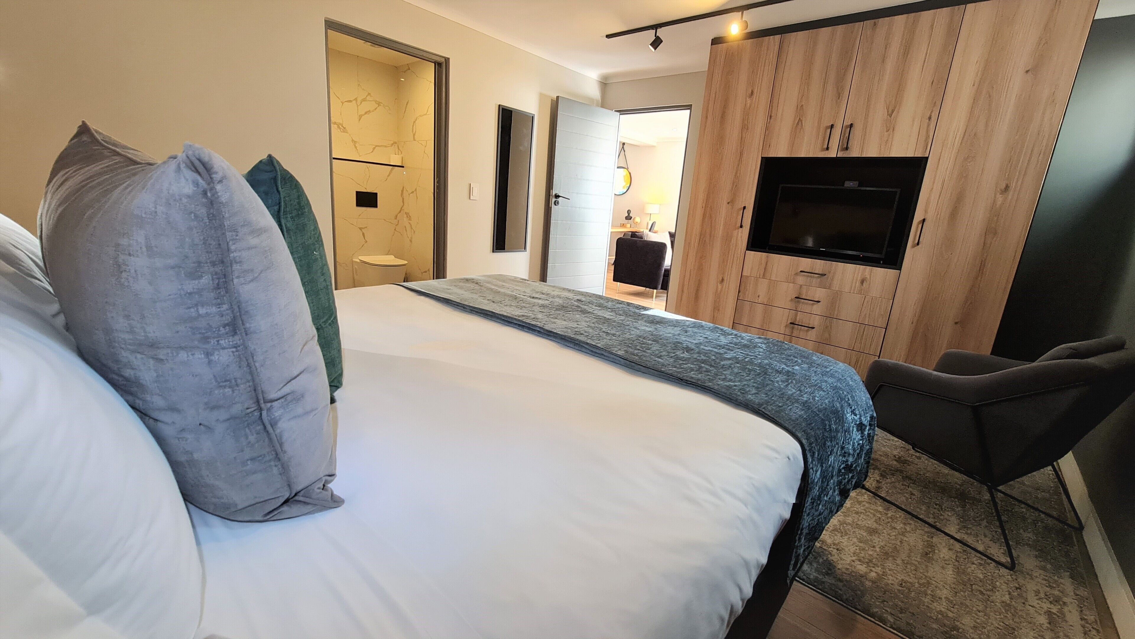 Une chambre d’hôtel avec un lit, une télévision, un bureau et une chaise.