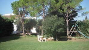 A grassy outdoor area with a swing set and two white chairs. - Holiday flat of the size of 45 m² on a large estate with pool close to Arles (Arles)