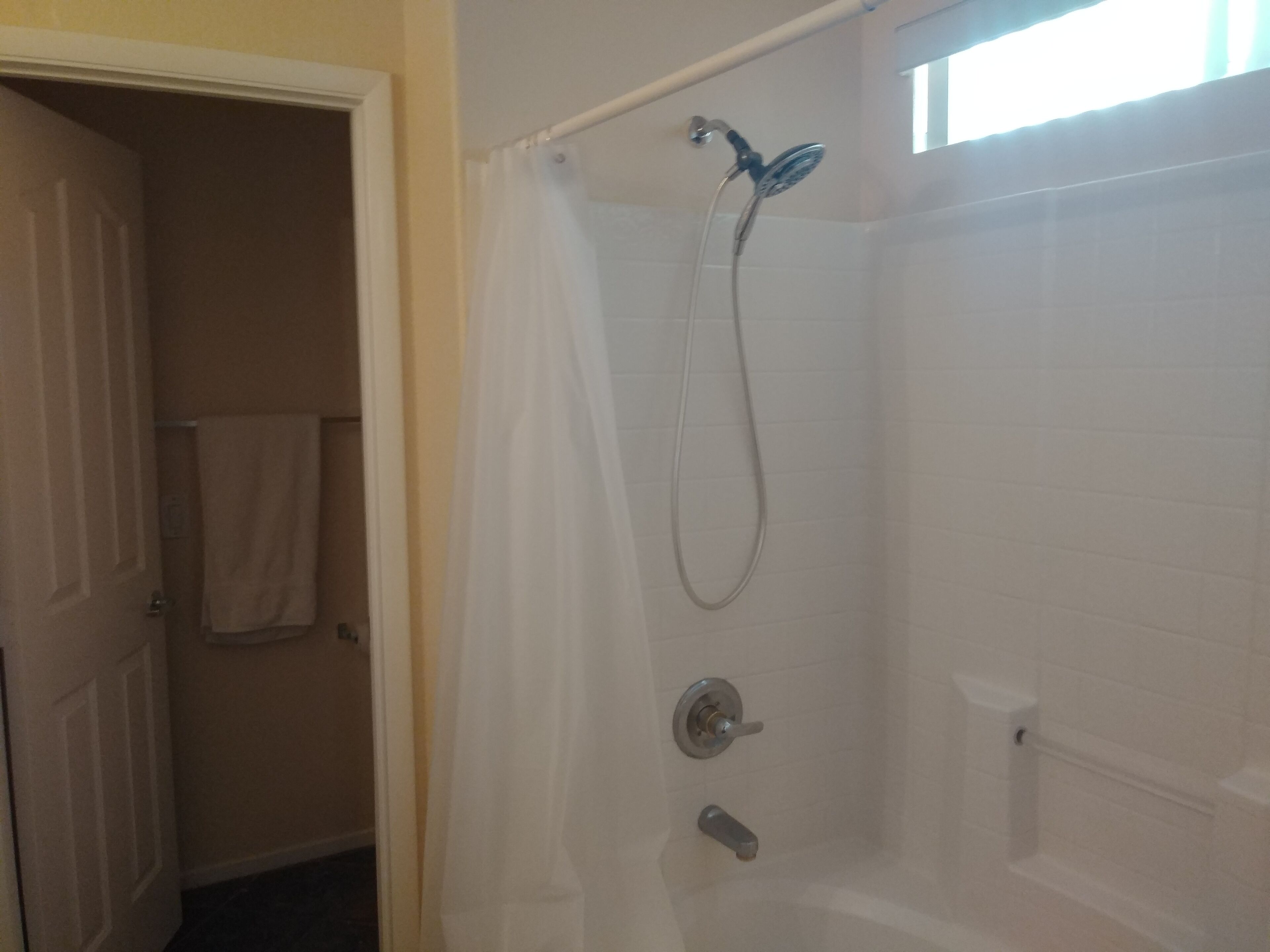 A bathroom with a shower, a toilet, and a bathtub.