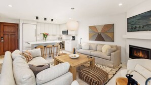 Un salon moderne avec un canapé, une table basse et une cheminée.